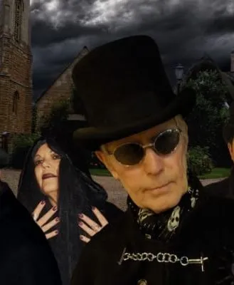 Four ghost walk guides in Gothic attire with dark hats and cloaks, posing with a dramatic, stormy sky in the background.