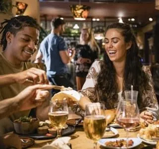 Group of friends enjoying dinner and drinks at a restaurant