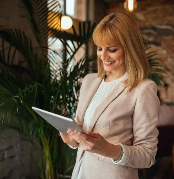 Businesswoman smiling while using a digital tablet indoors