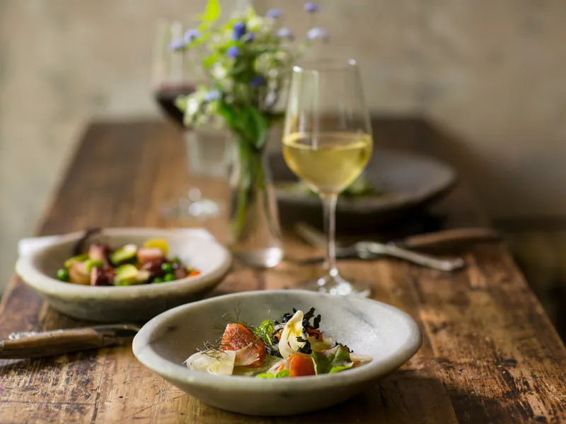 Gourmet meal served with white wine on a rustic wooden table