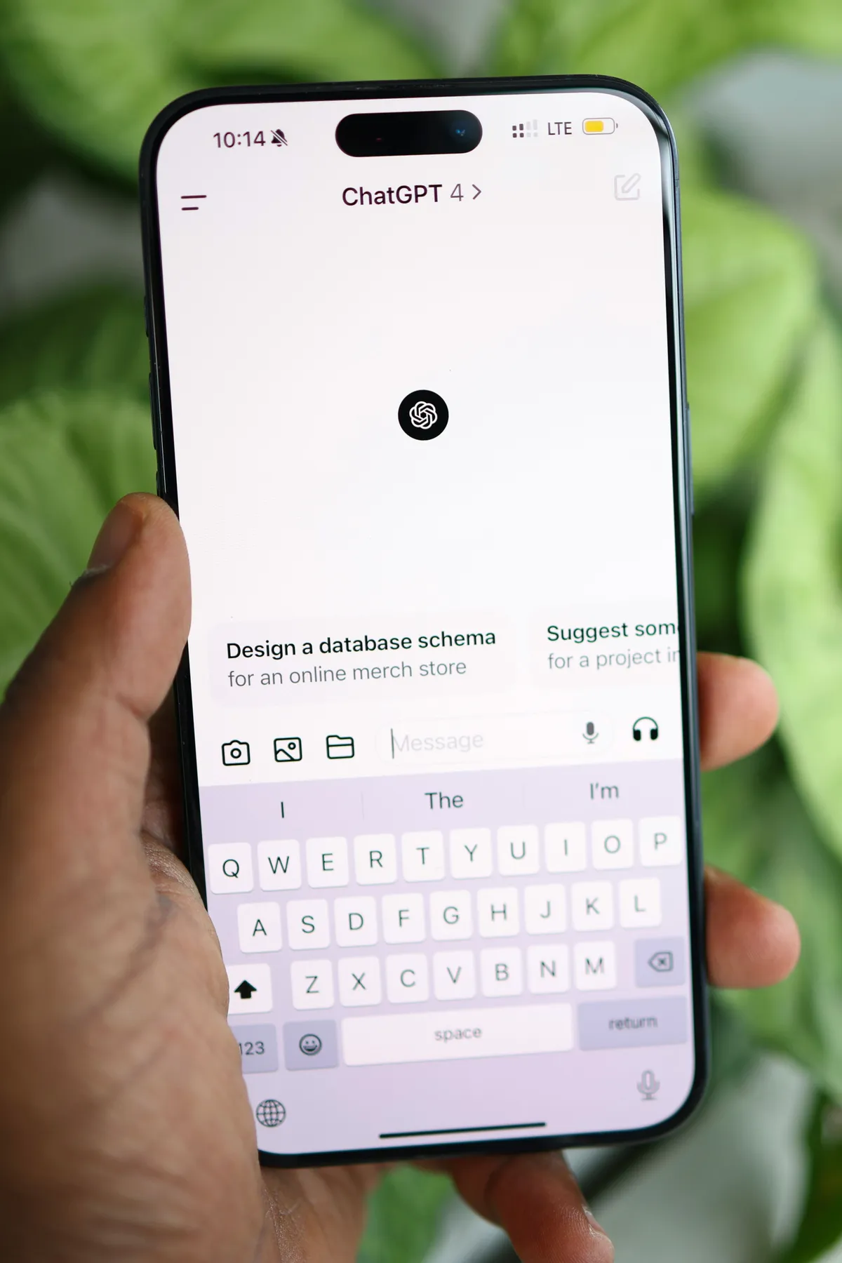 Hand holding a smartphone displaying the ChatGPT app interface