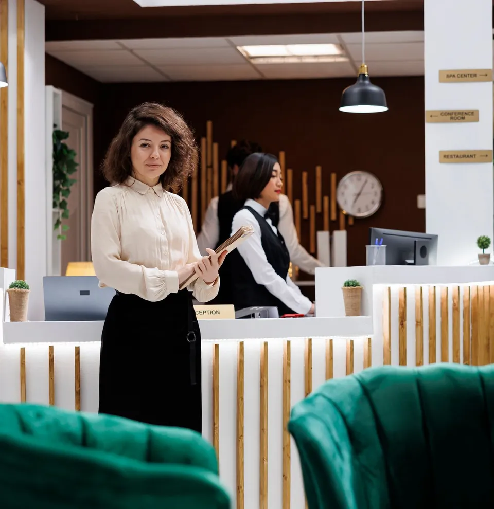 Reception area in a modern hotel with a receptionist and a guest holding a clipboard