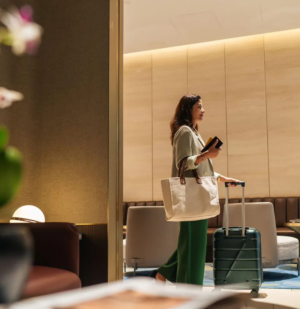Woman with suitcase entering a modern lounge area