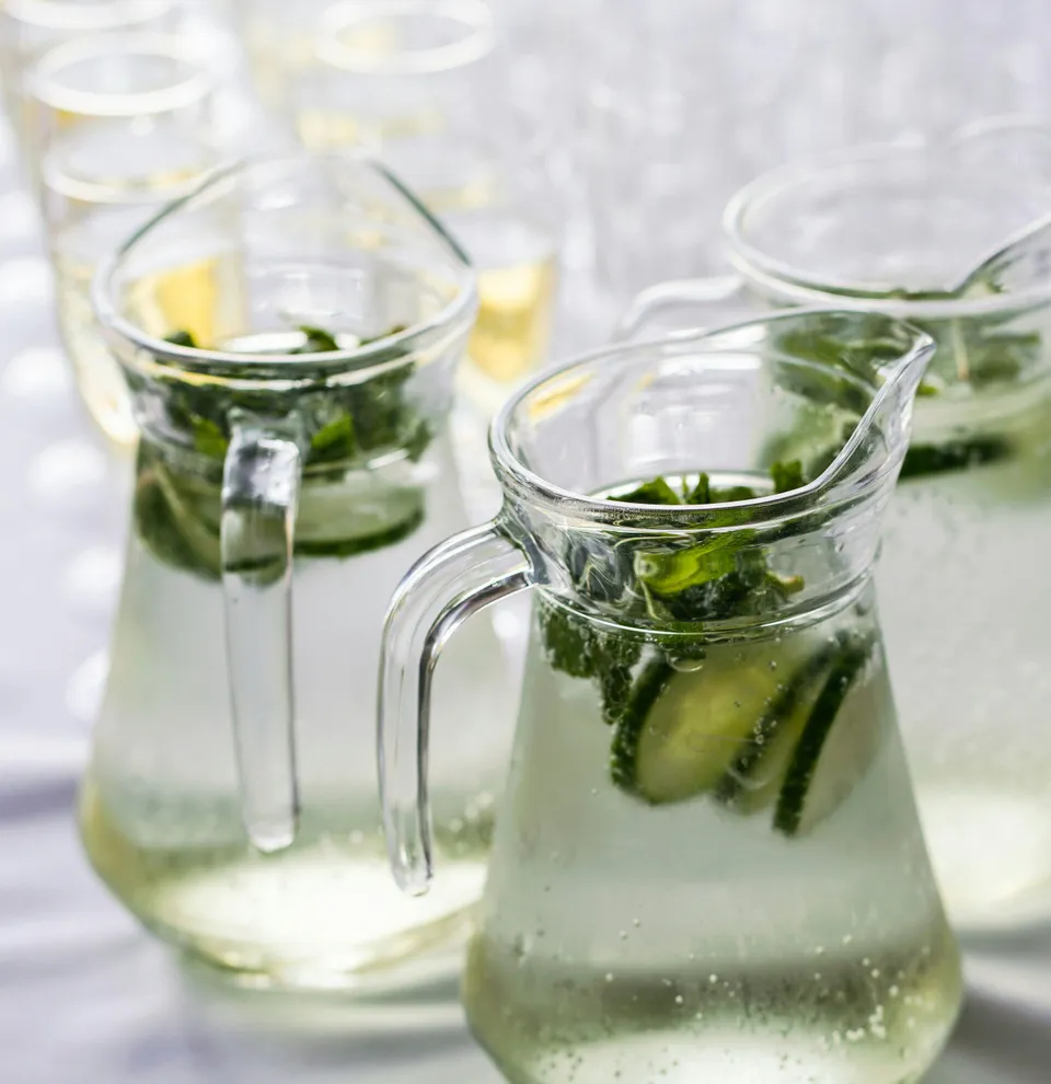 Three glass pitchers filled with refreshing cucumber and mint water