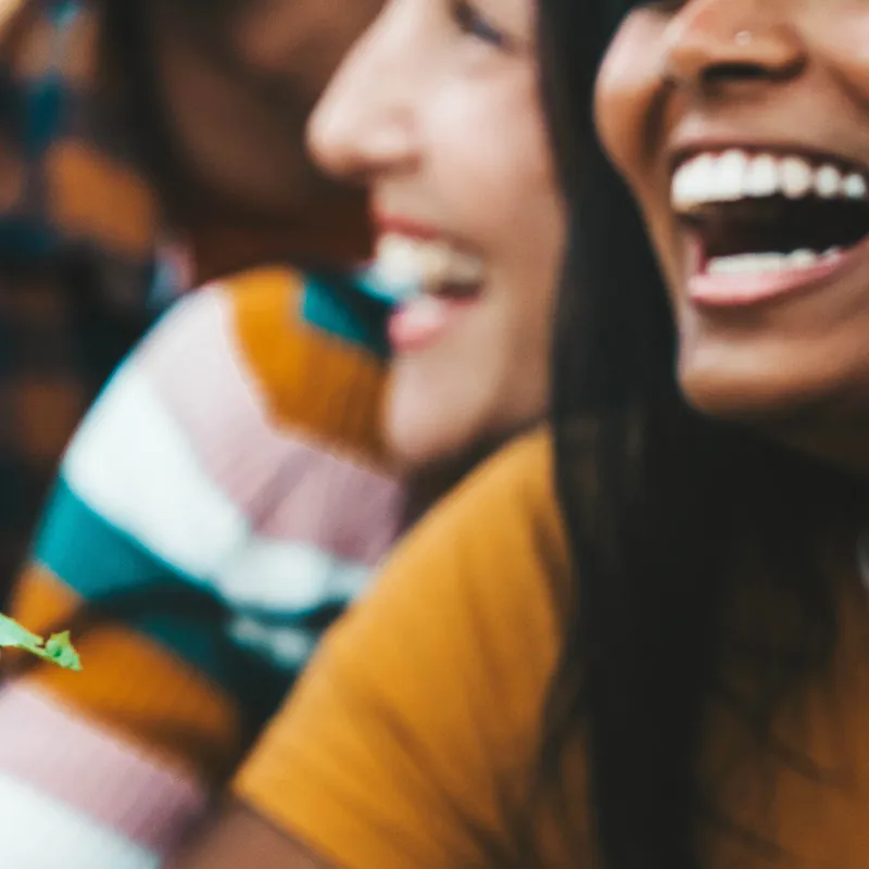 Close-up of two people laughing and smiling together