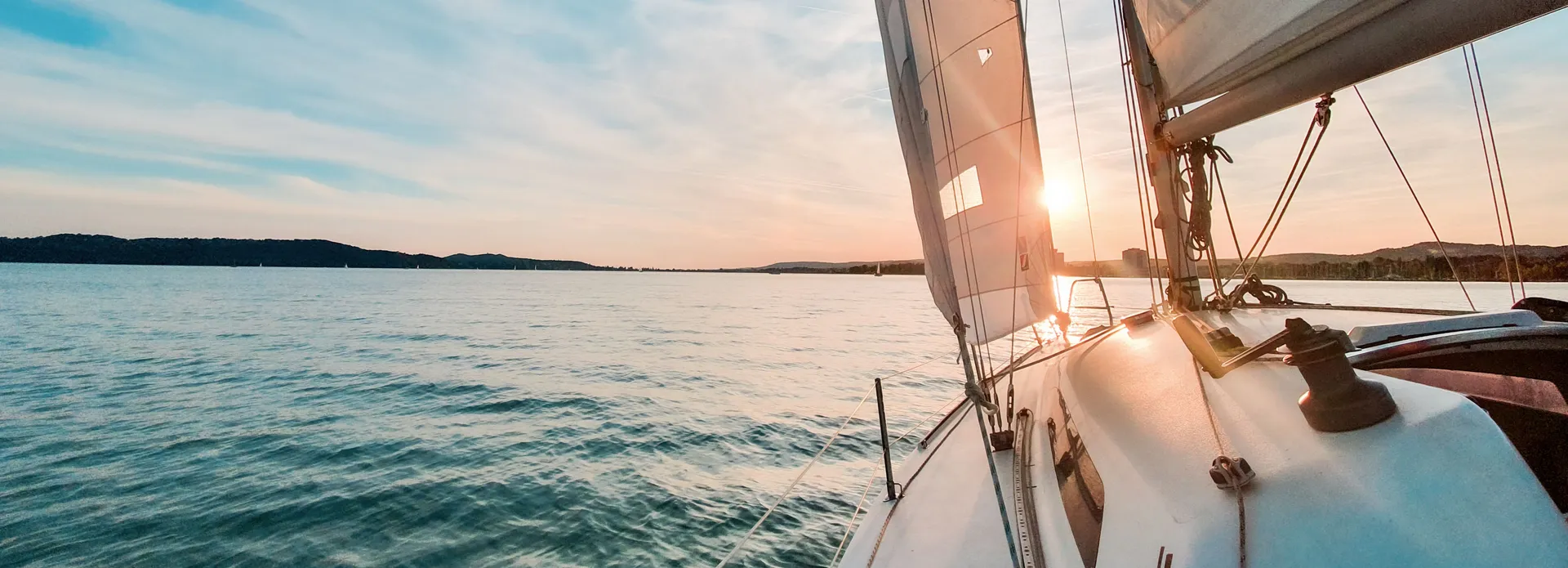 Sailboat on calm water at sunset