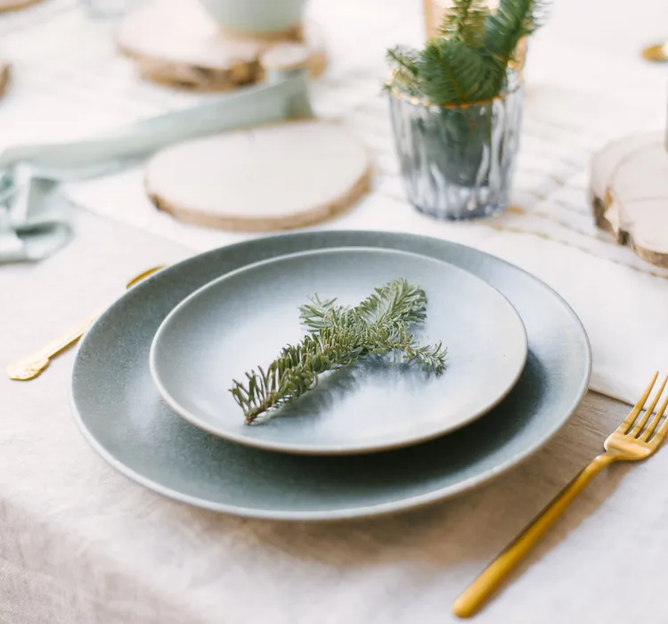 Elegant holiday table setting with pine branch on plate