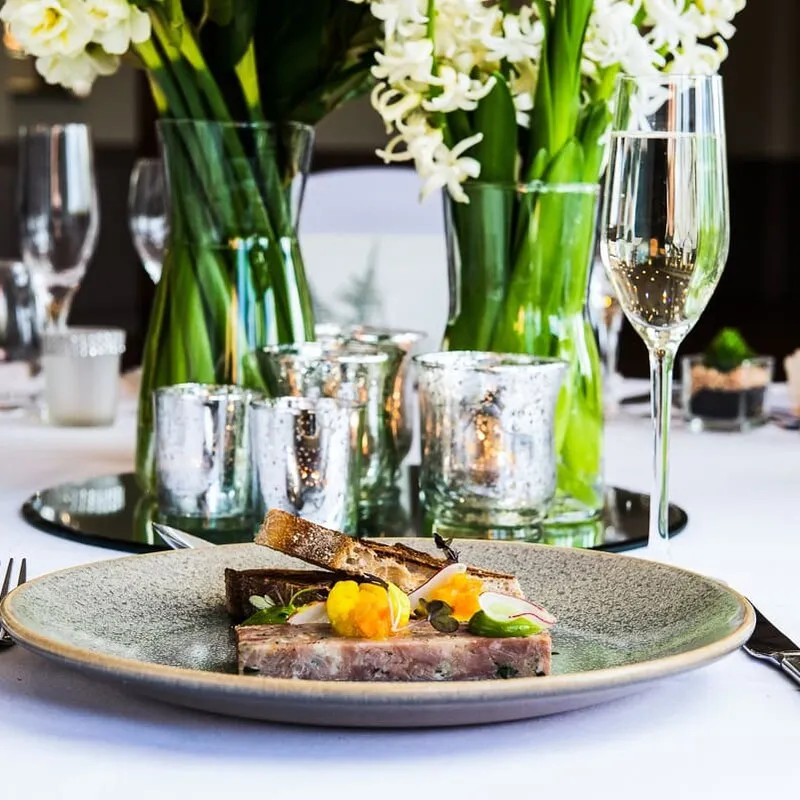 Elegant wedding table setting with gourmet plated food and champagne
