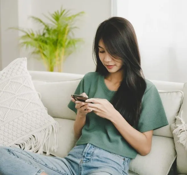 Woman sitting on a sofa looking at her smartphone