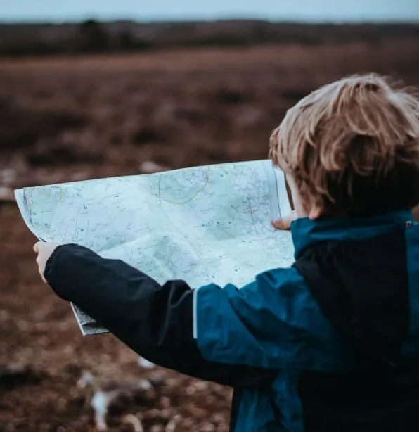 Child holding and looking at a map outdoors