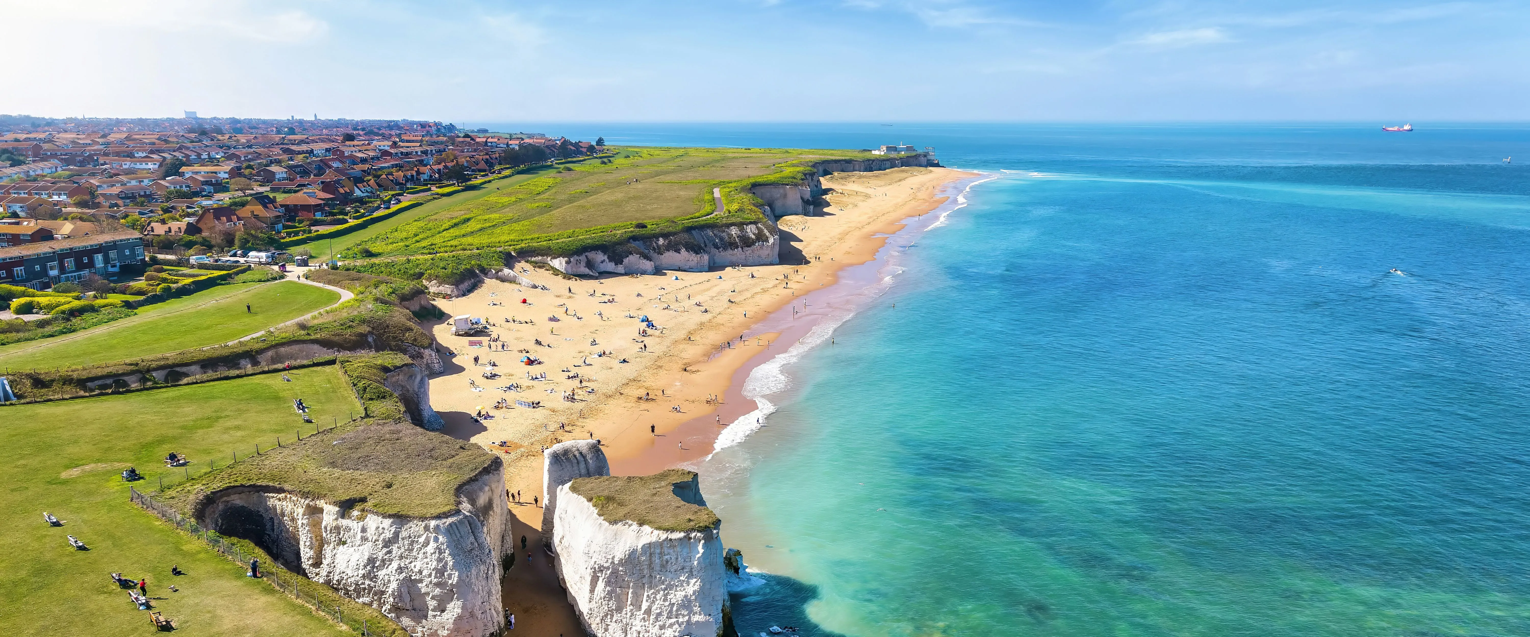 Aerial view of white chalk cliffs, sandy beach and turquoise sea along the coast at Broadstairs, Kent.