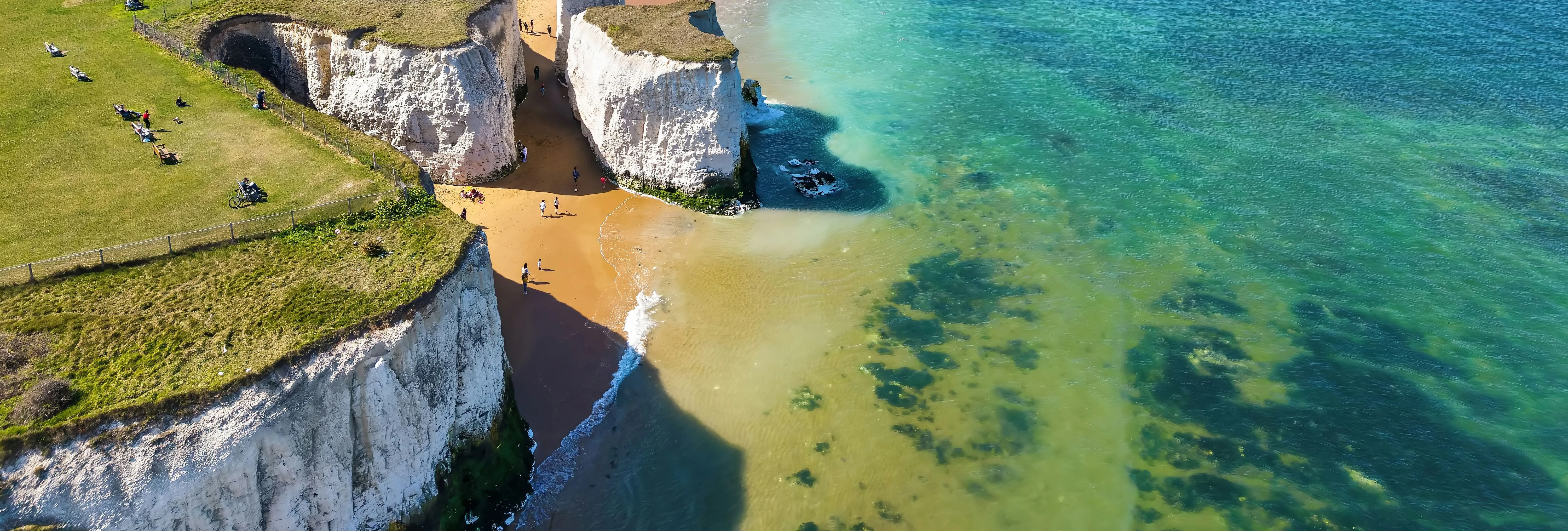 Aerial view of white chalk cliffs, sandy beach and turquoise sea along the coast at Broadstairs, Kent.