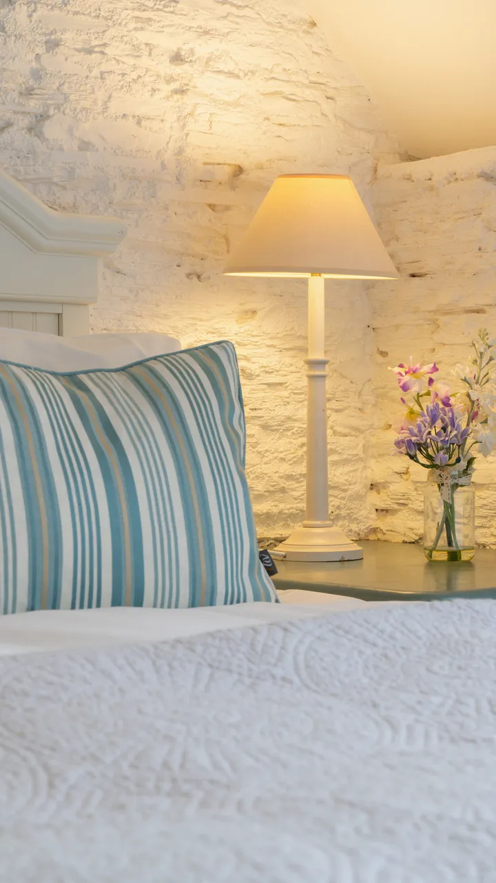 Detail photo of the bed in the dairy with small vase of flowers