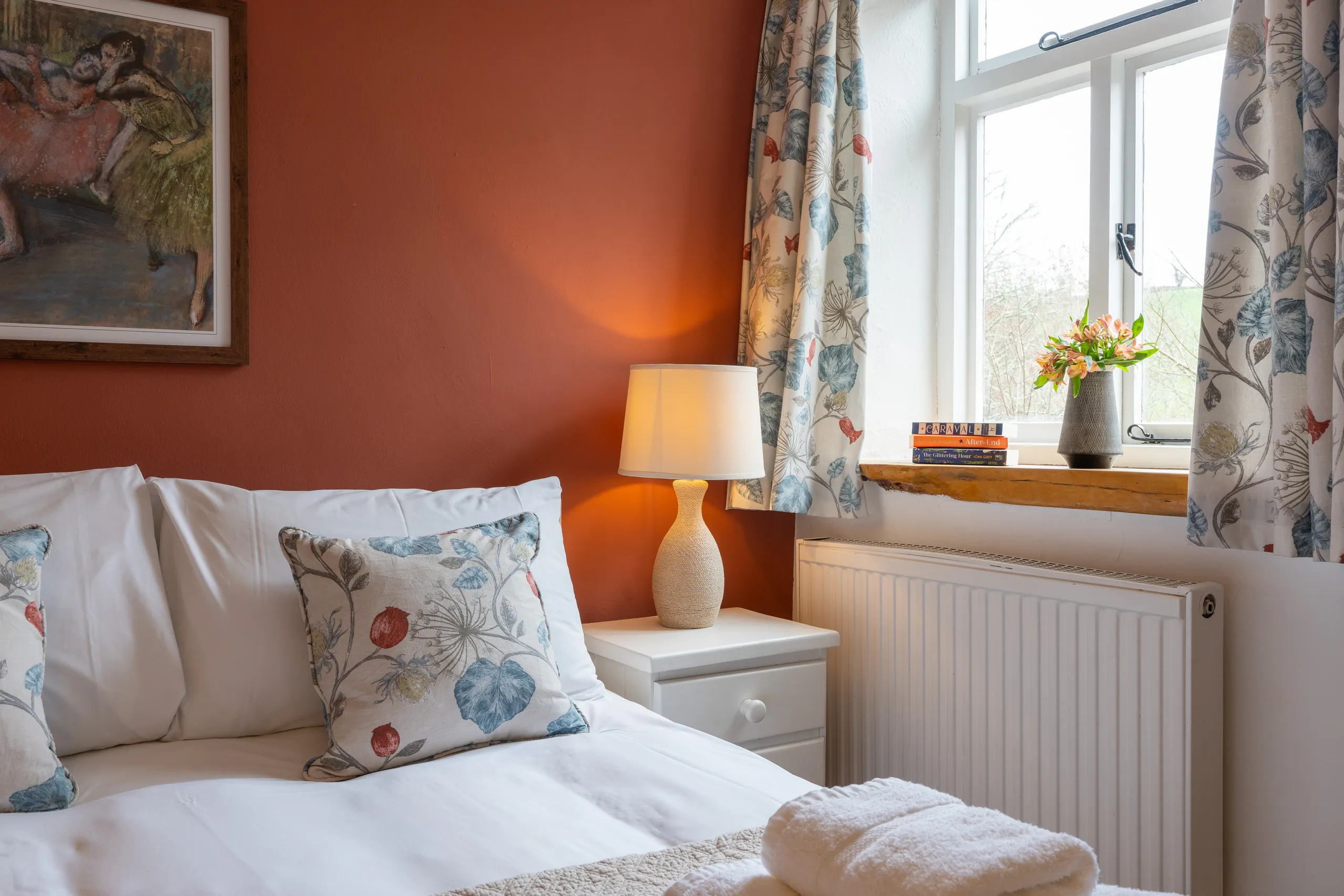 Stables main bedroom with terracotta colour feature wall