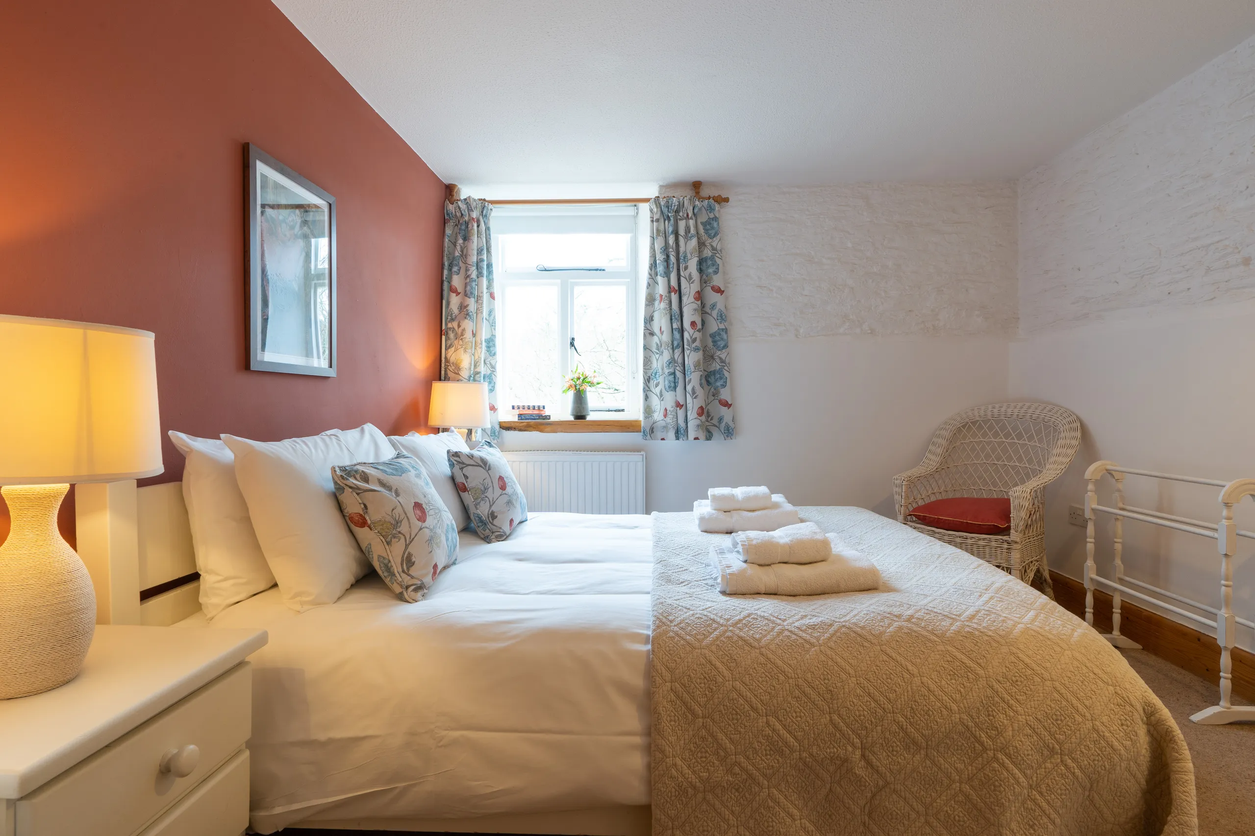 Stables main bedroom with terracotta colour feature wall
