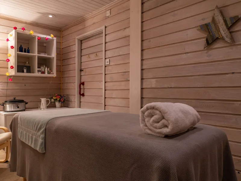 Cosy treatment room with massage bed