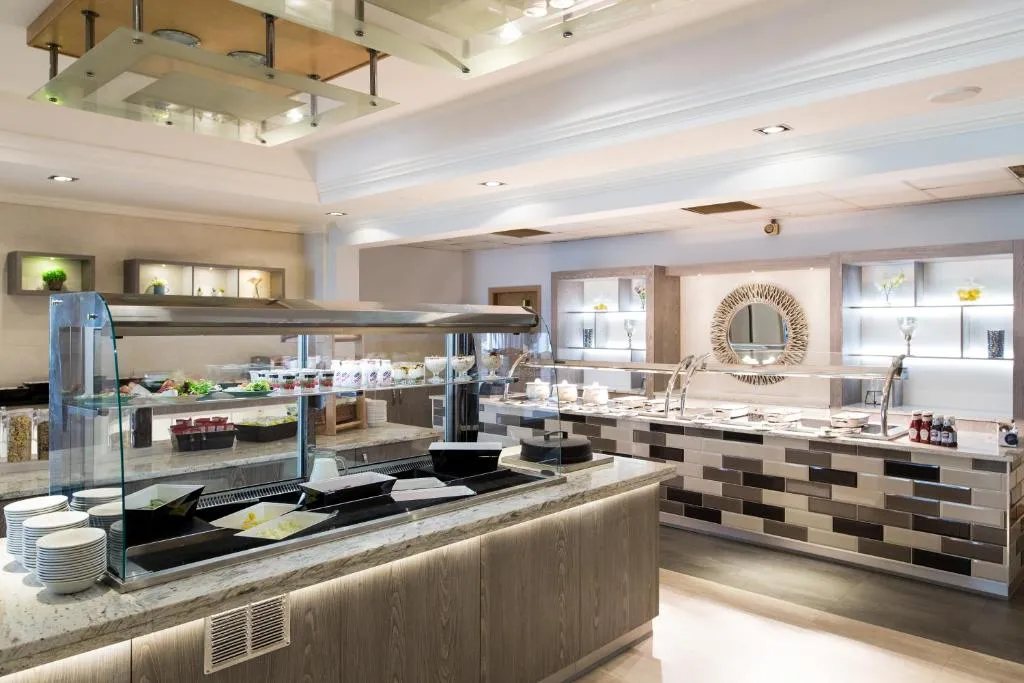 Modern hotel buffet area with glass food counters, salad dishes and serving stations