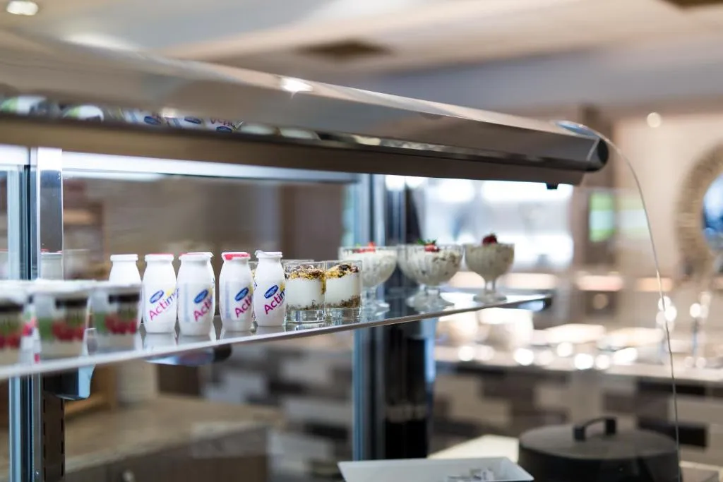 Chilled glass display cabinet containing probiotic yoghurt drinks and dessert pots.