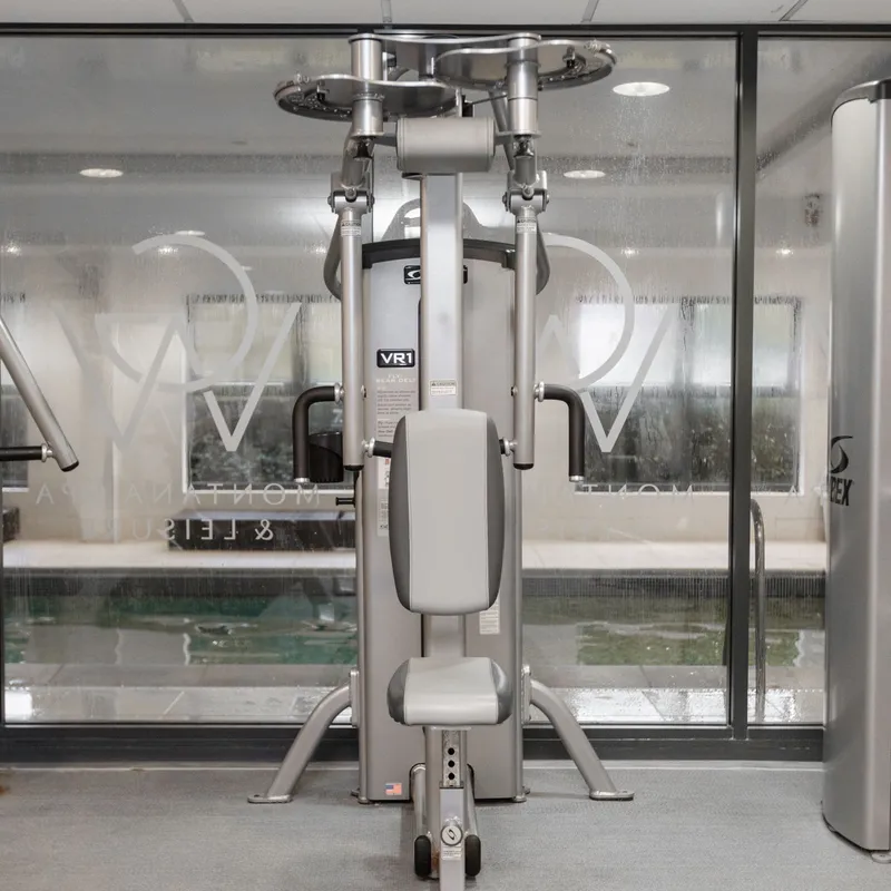 Seated shoulder press exercise machine in a modern gym