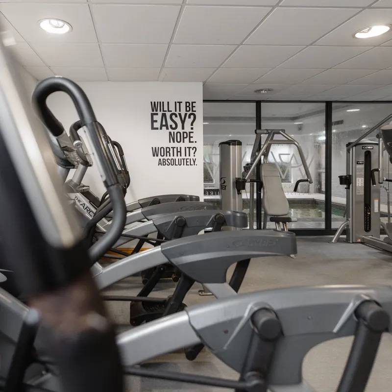Modern gym interior with exercise machines and a motivational wall quote