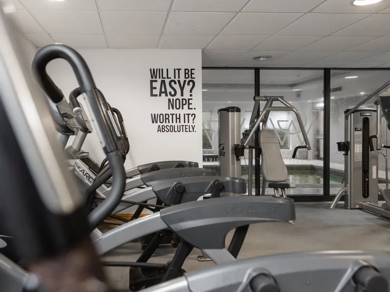 Modern gym interior with exercise machines and a motivational wall quote