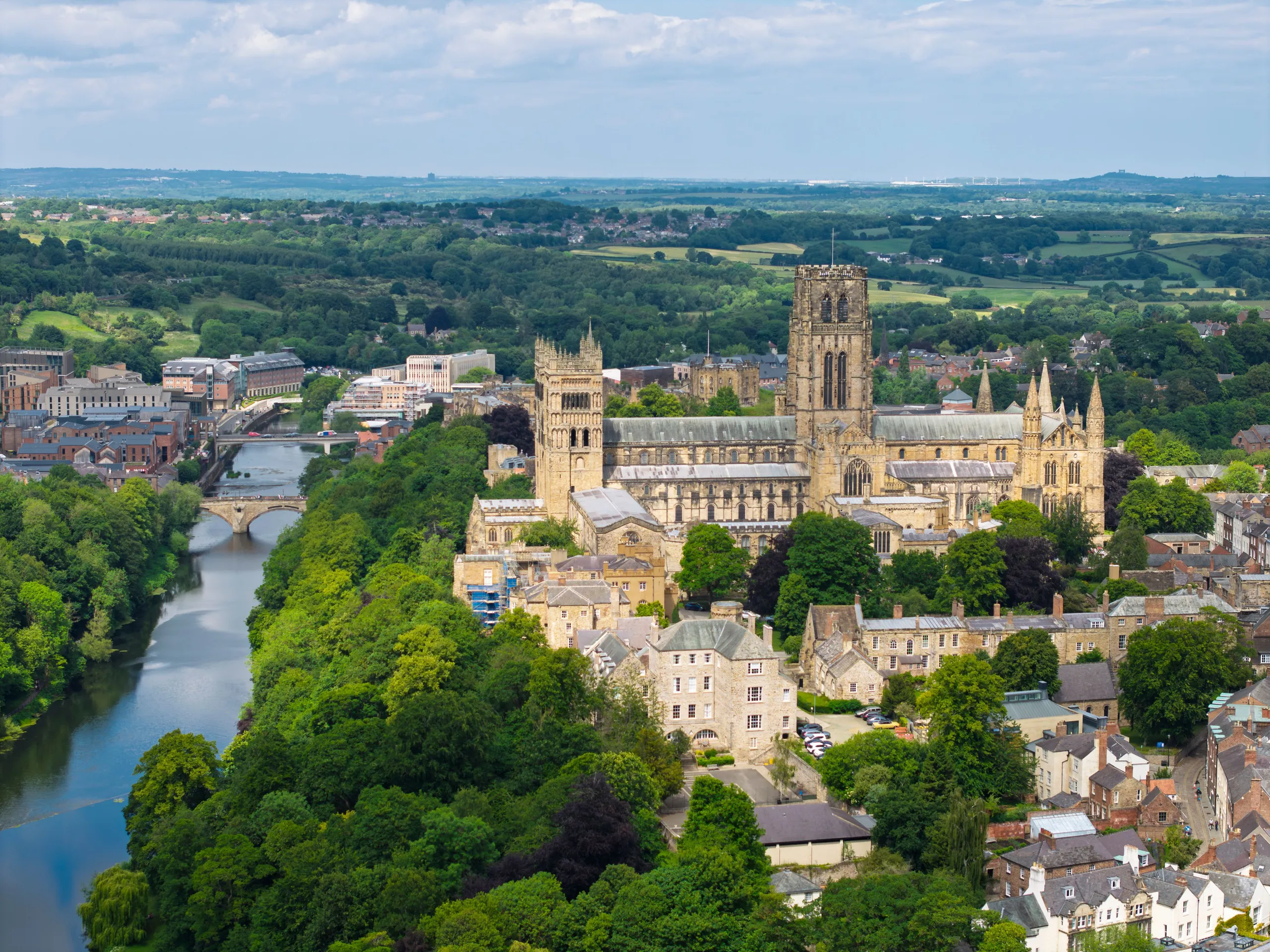 Aerial view of Durham Cathedral beside the River Wear, surrounded by the historic city and green countryside.