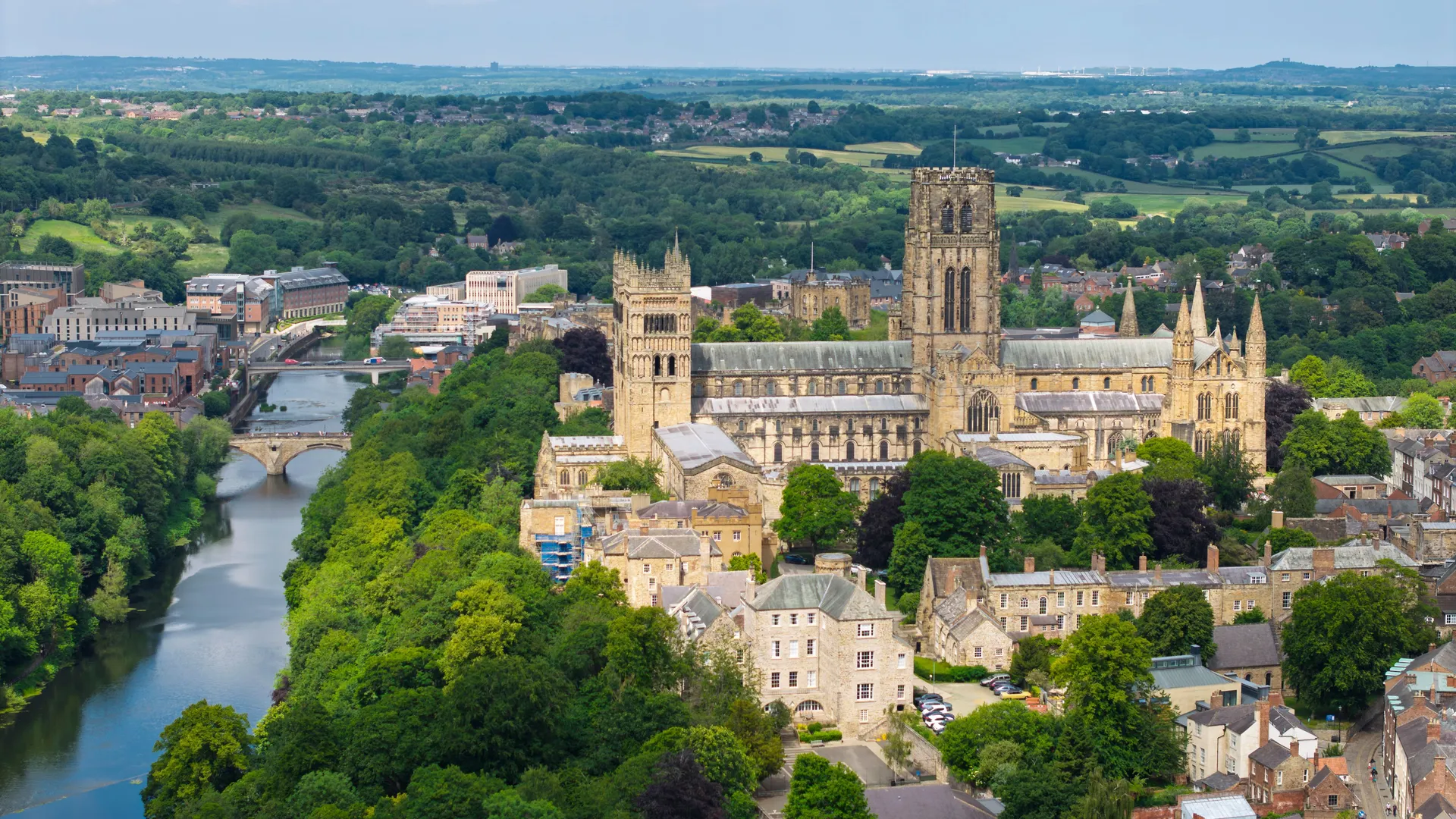 Aerial view of Durham Cathedral beside the River Wear, surrounded by the historic city and green countryside.
