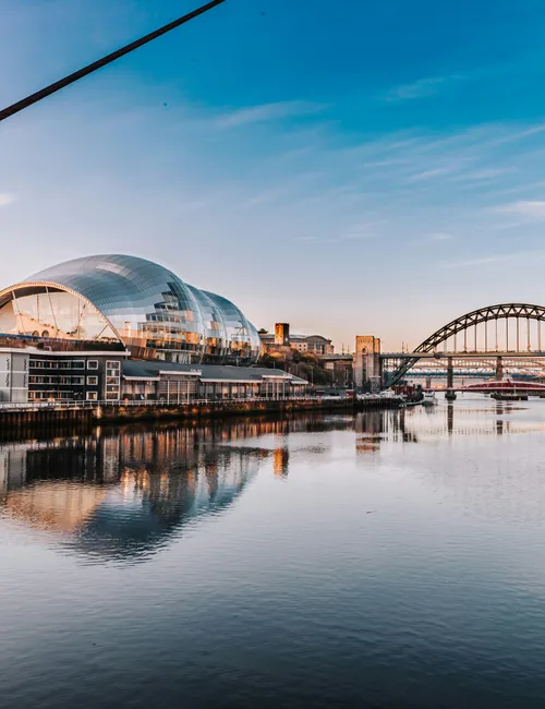 The Sage Gateshead and Tyne Bridge reflected in the River Tyne at sunset