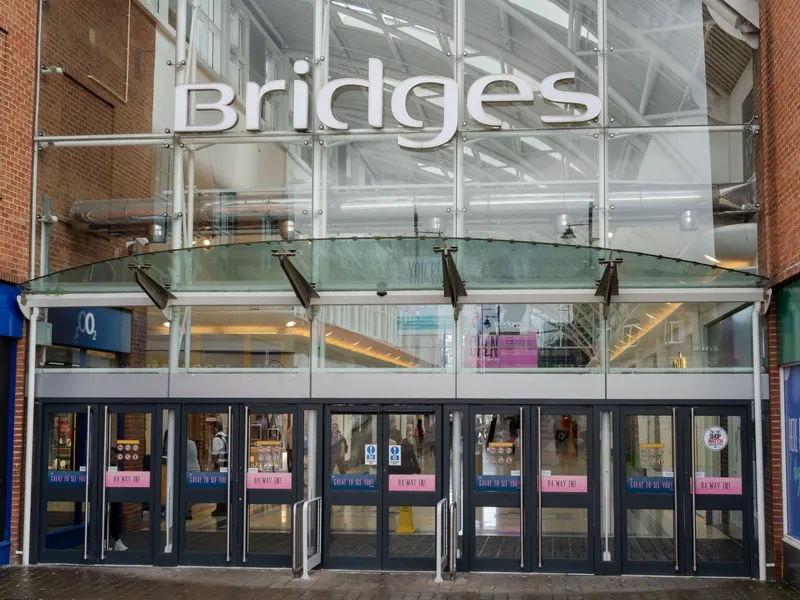 Glass-fronted entrance to Bridges shopping centre with its name displayed above the doors