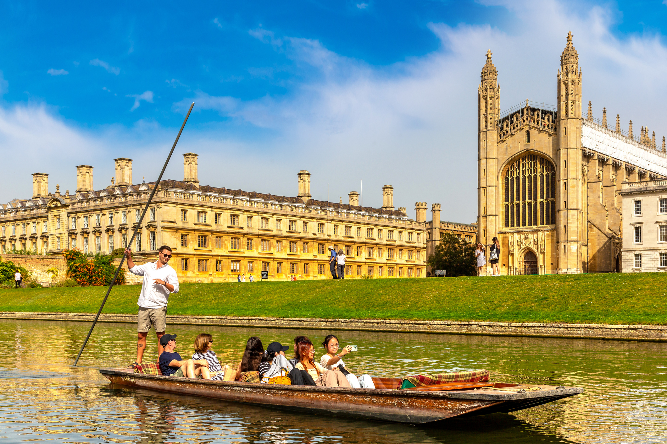 Punt carrying passengers along The Backs in Cambridge, with King&rsquo;s College Chapel and historic college buildings in the background.