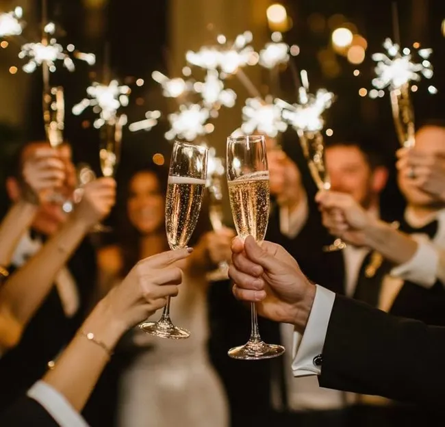 People toasting with champagne glasses and sparklers at a festive celebration