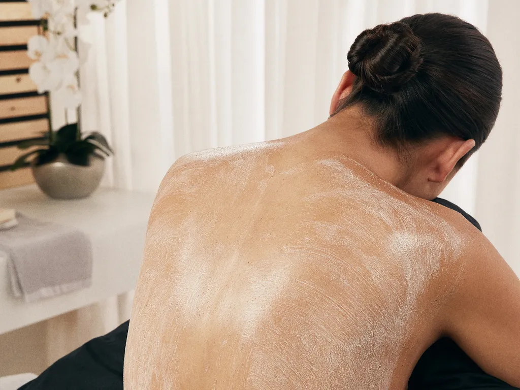 Person receiving a spa treatment with cream applied to their back