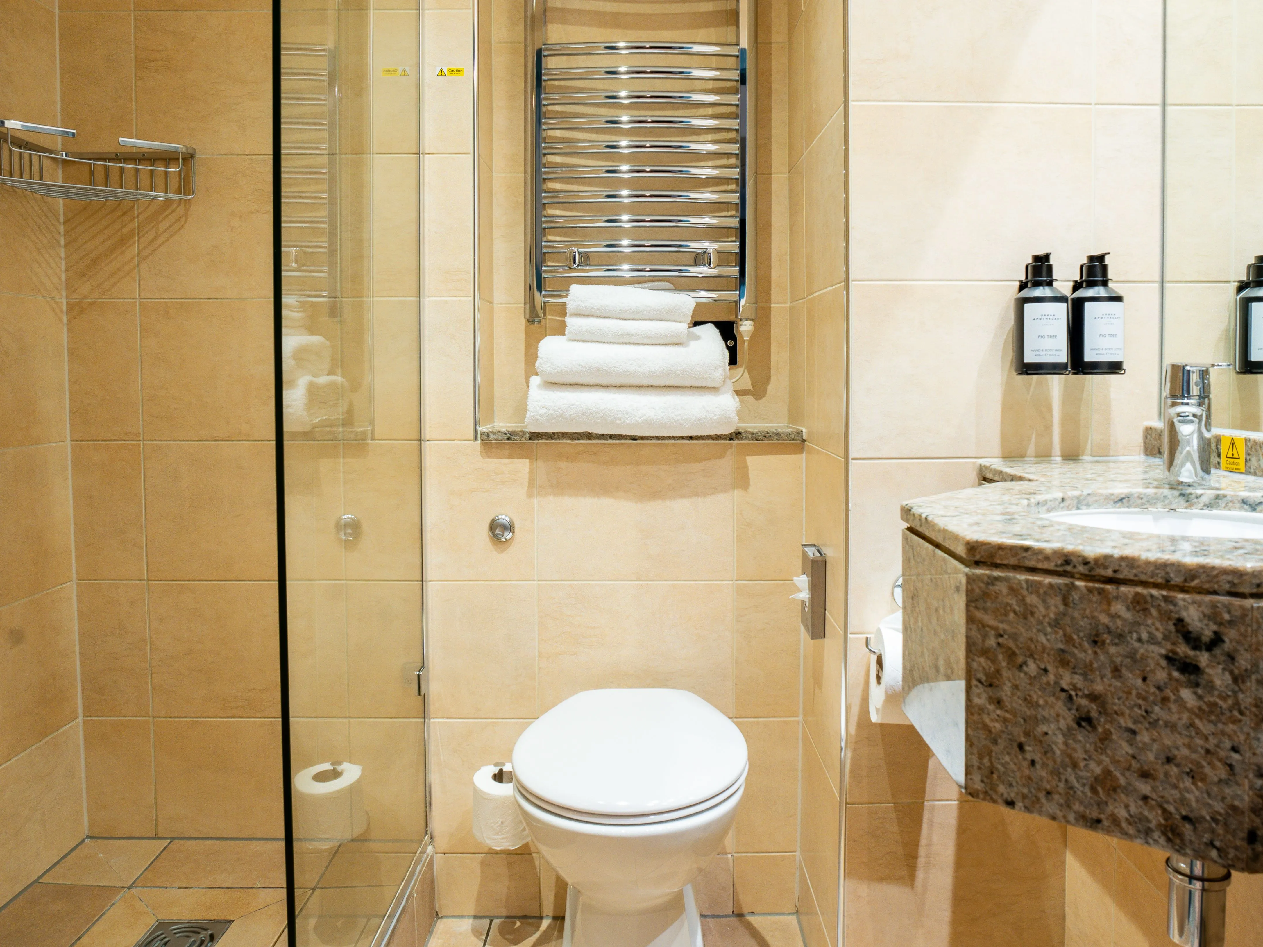 Modern bathroom with walk-in shower, toilet, heated towel rail and granite sink unit