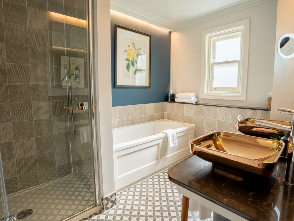 Modern bathroom with walk-in shower, bathtub and metallic basin sink