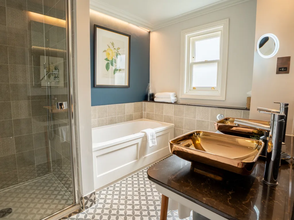 Modern bathroom with walk-in shower, bathtub and metallic basin sink