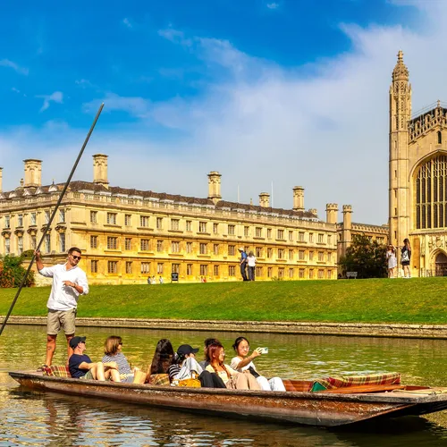 People punting on the River Cam beside King’s College Chapel in Cambridge on a bright sunny day.