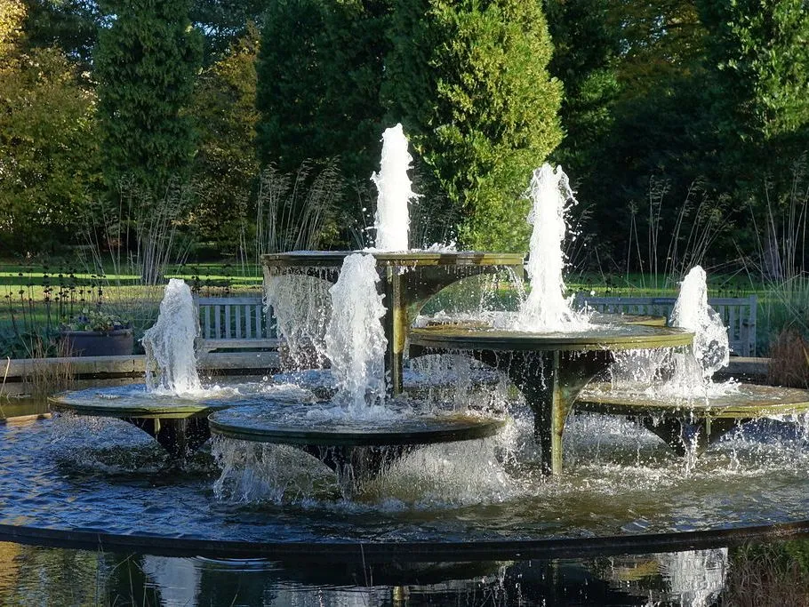 Tiered water fountain with multiple streams in a botanical garden setting