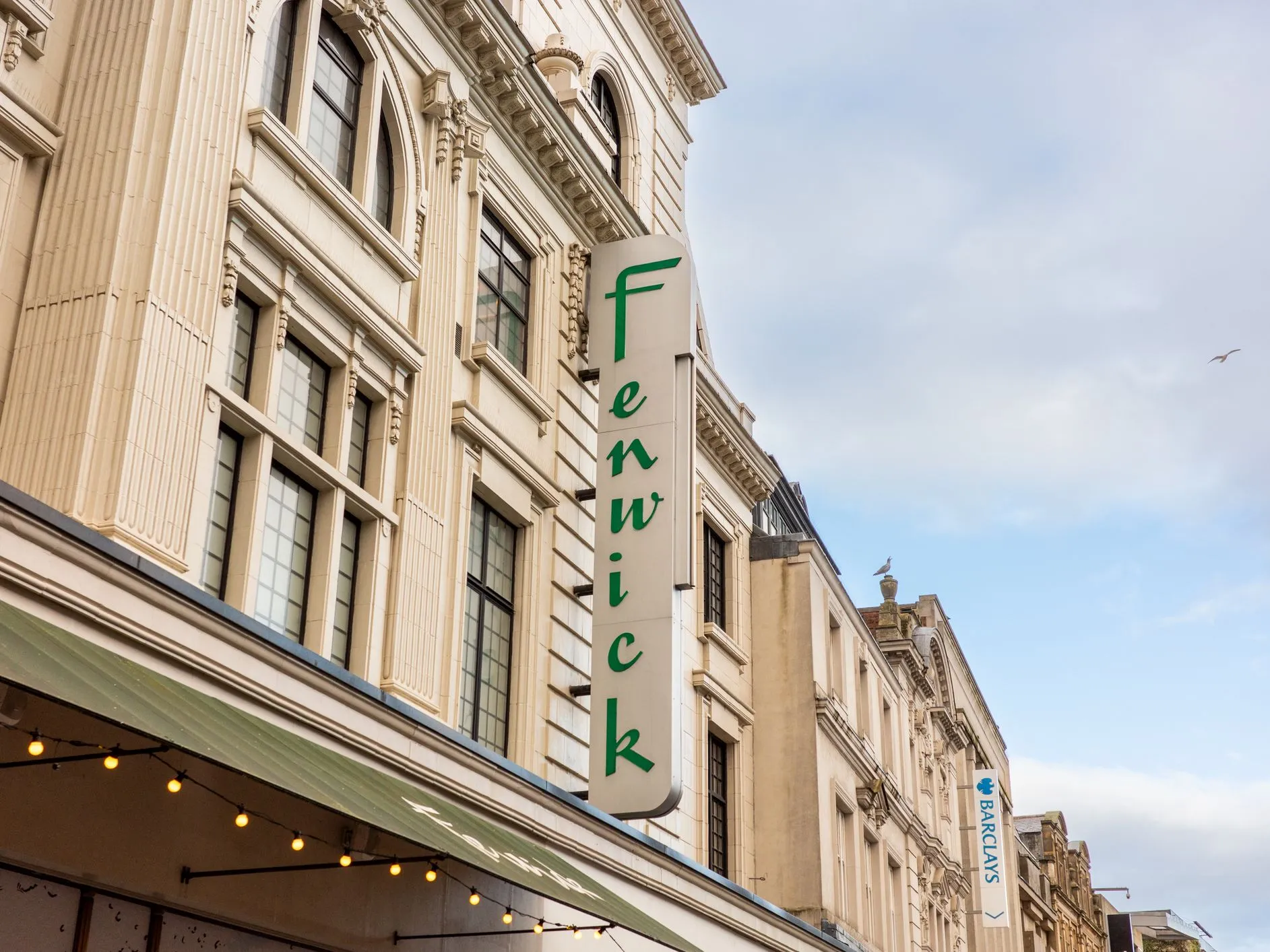 Vertical Fenwick shop sign on the exterior of a grand department store building in a city centre street.