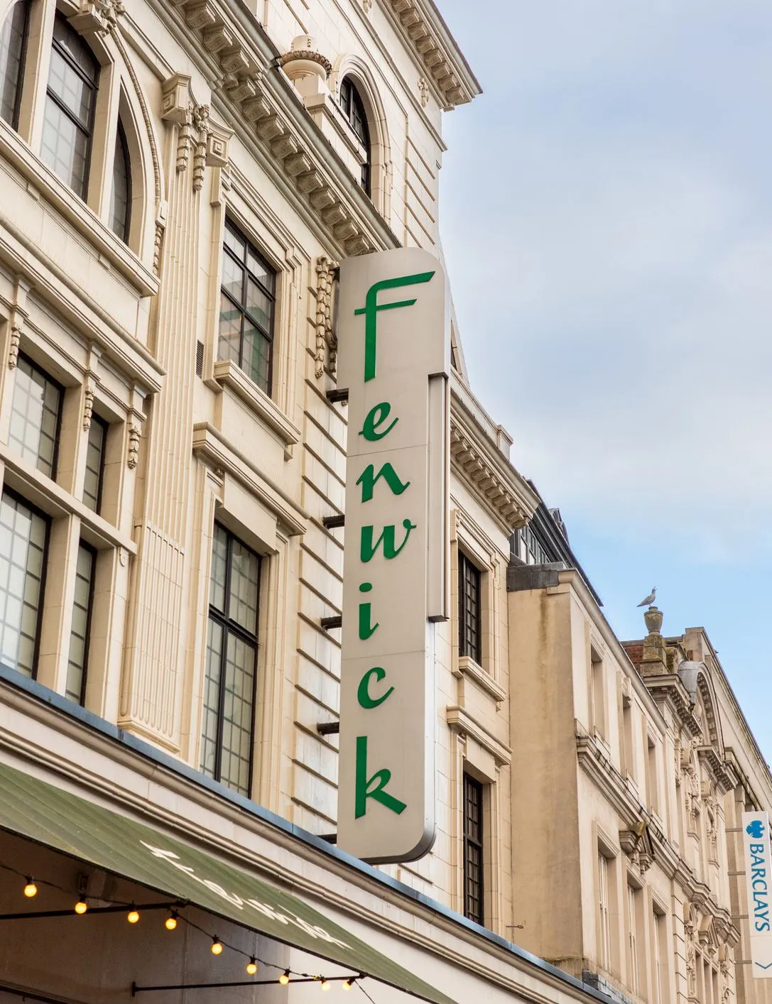 Vertical Fenwick shop sign on the exterior of a grand department store building in a city centre street.