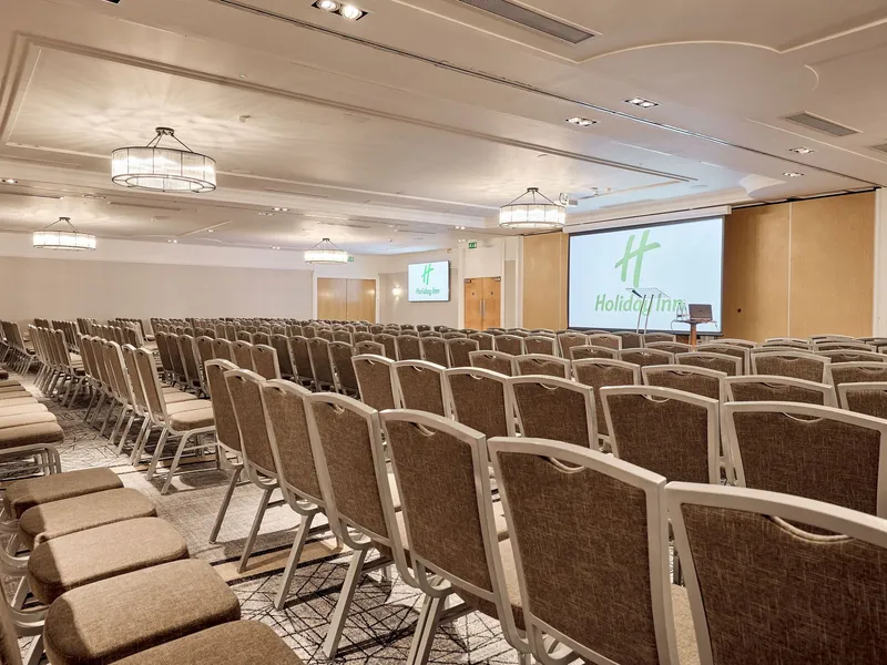 Conference room with rows of chairs facing a presentation screen at Holiday Inn