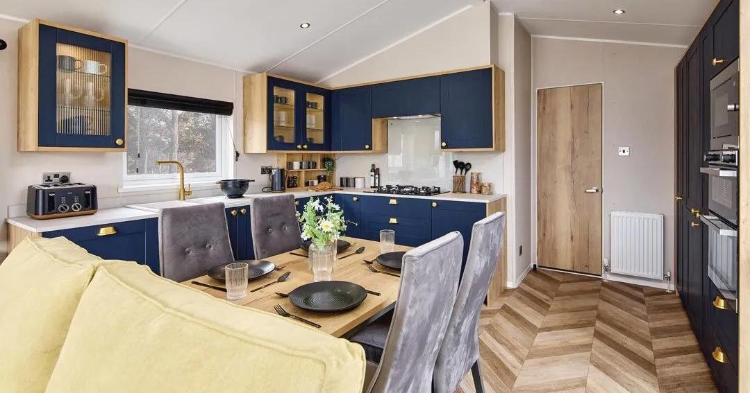Modern kitchen diner with navy cabinets, wooden worktops and dining table set for four