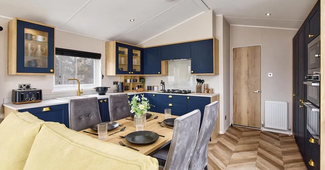 Modern kitchen diner with navy cabinets, wooden worktops and dining table set for four