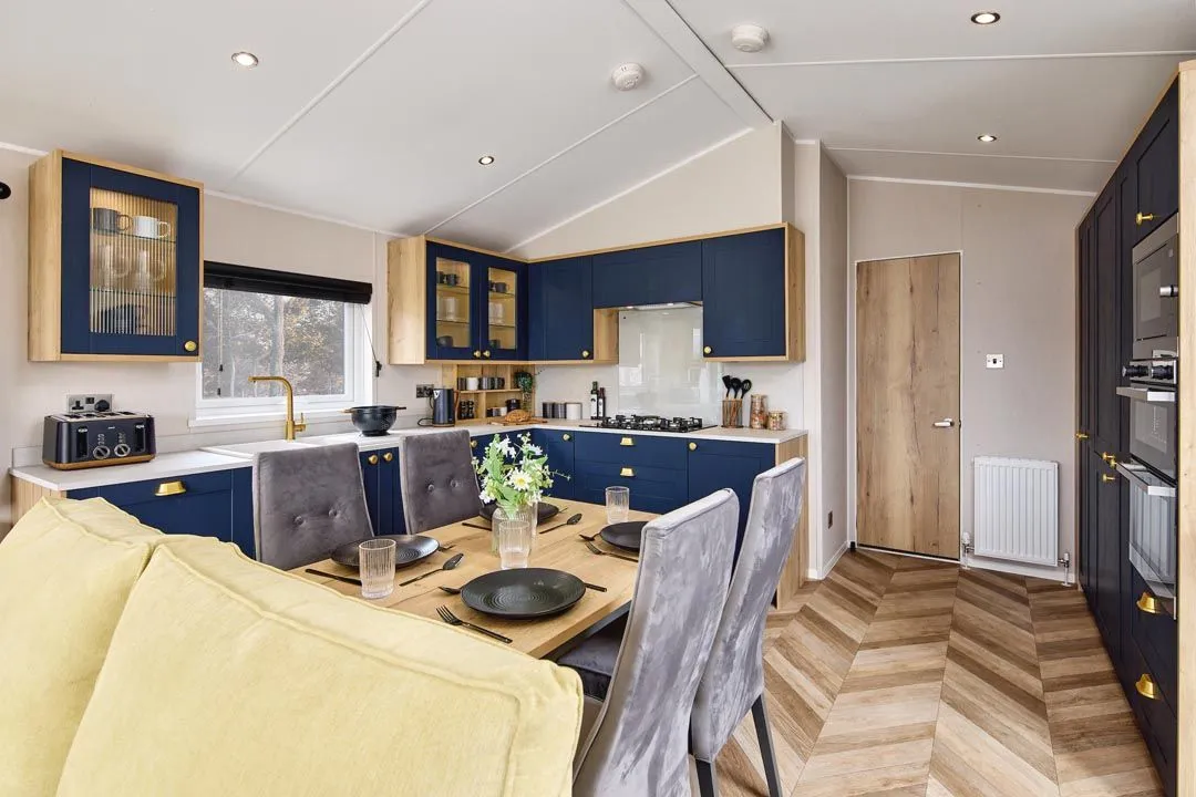Modern kitchen diner with navy cabinets, wooden worktops and dining table set for four