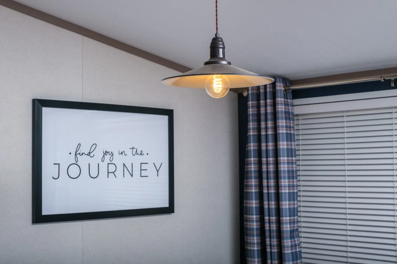 Pendant light above framed quote reading 