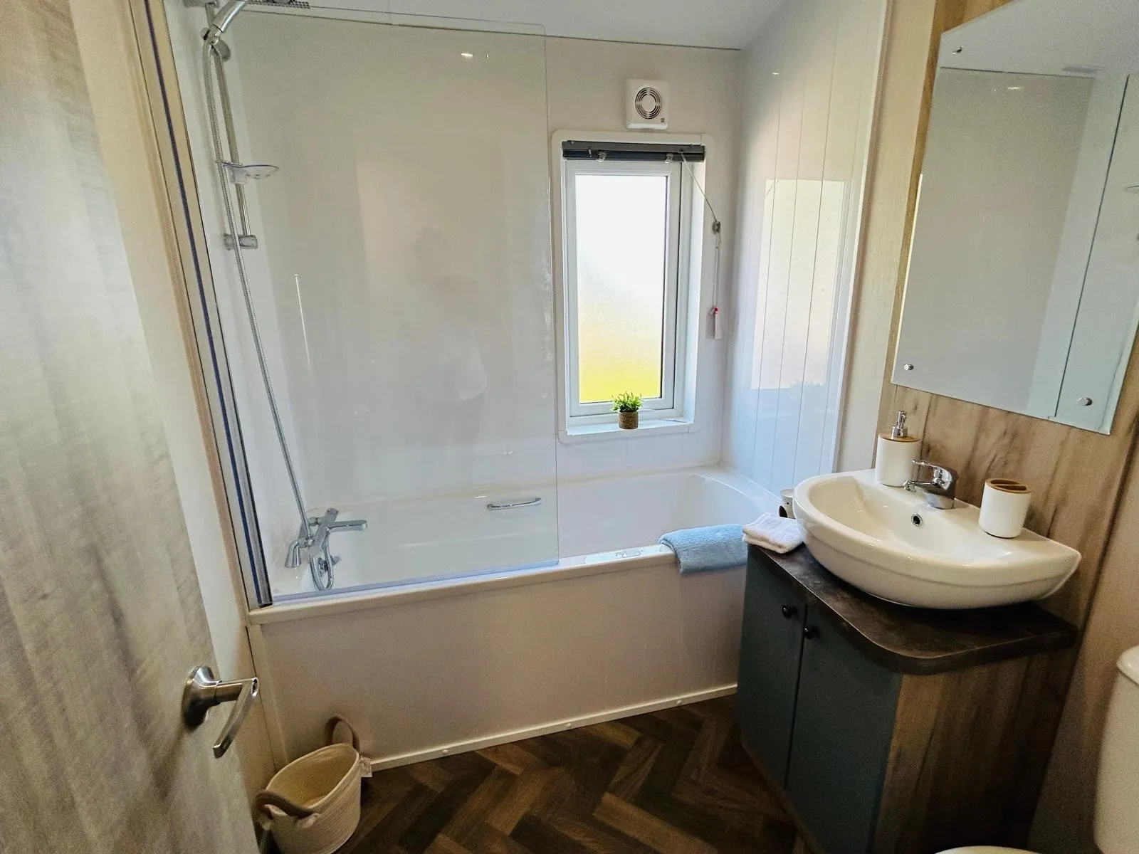Modern bathroom with bath and shower, frosted window and vanity sink