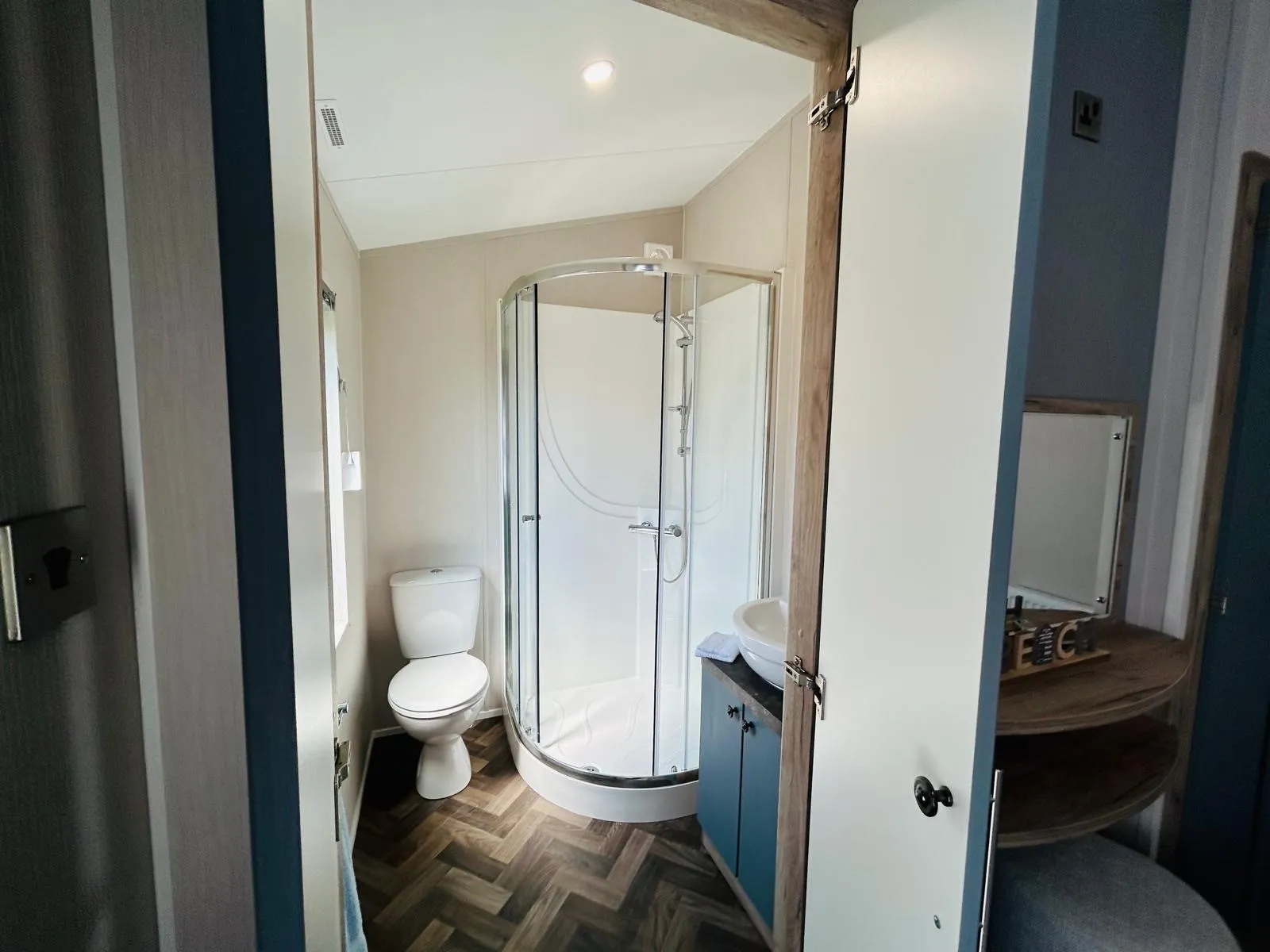 Compact bathroom with corner shower, toilet and vanity unit