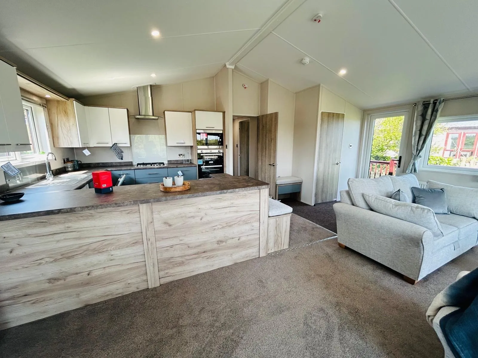 Open-plan kitchen and lounge with breakfast bar and sofa