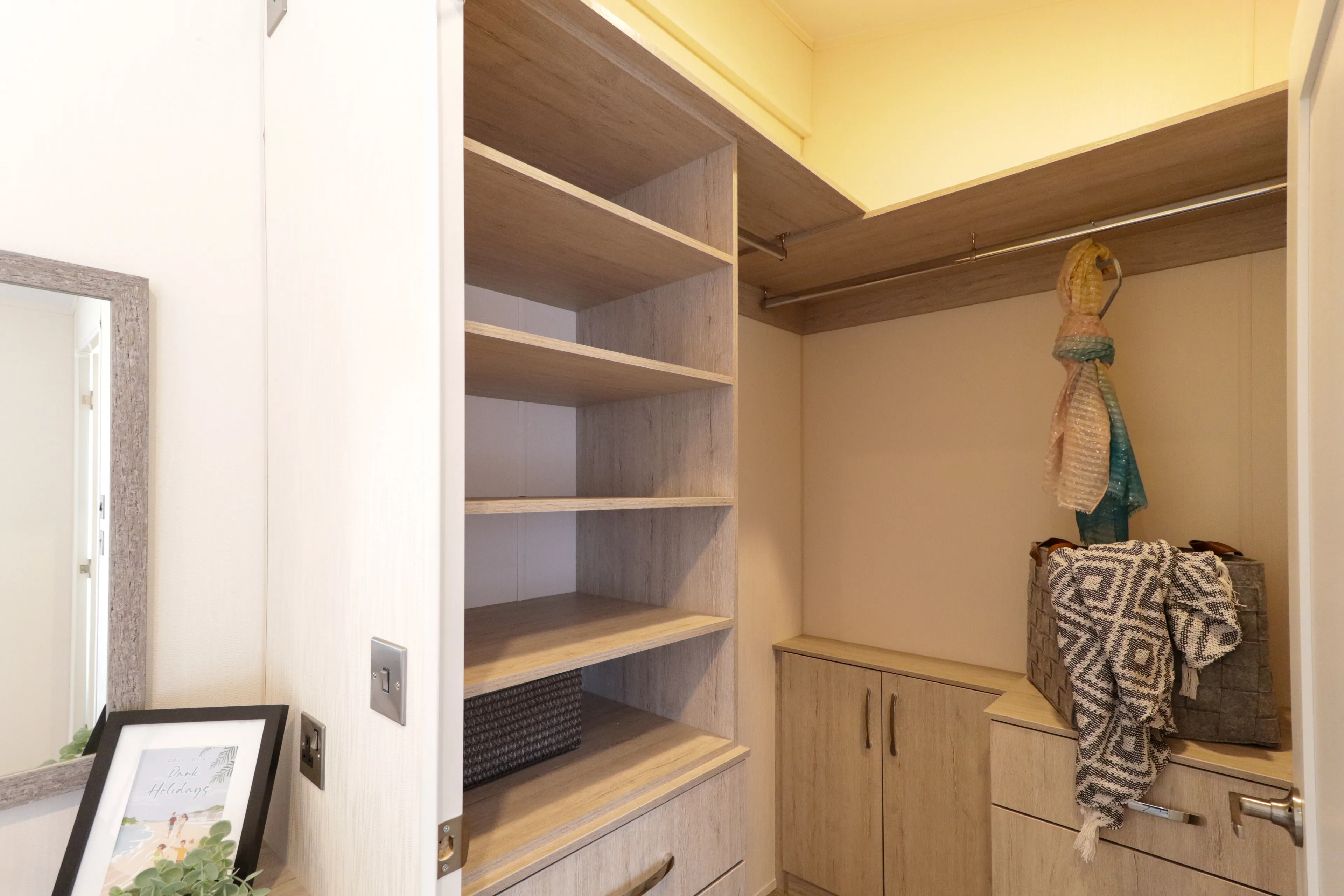 Walk-in wardrobe with built-in wooden shelves, hanging rail and storage bench