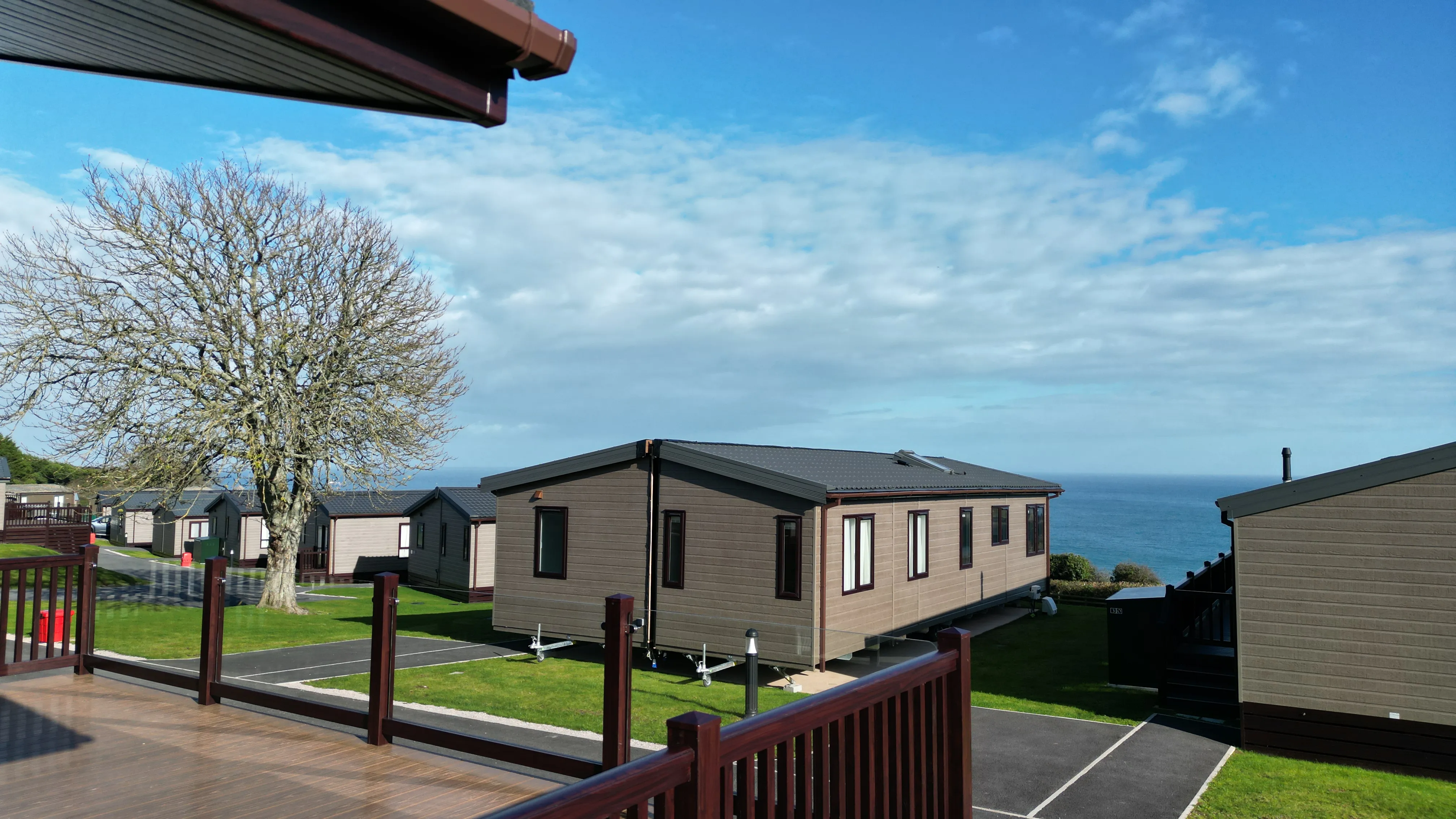 Static caravans on a coastal holiday park with sea view under a blue sky