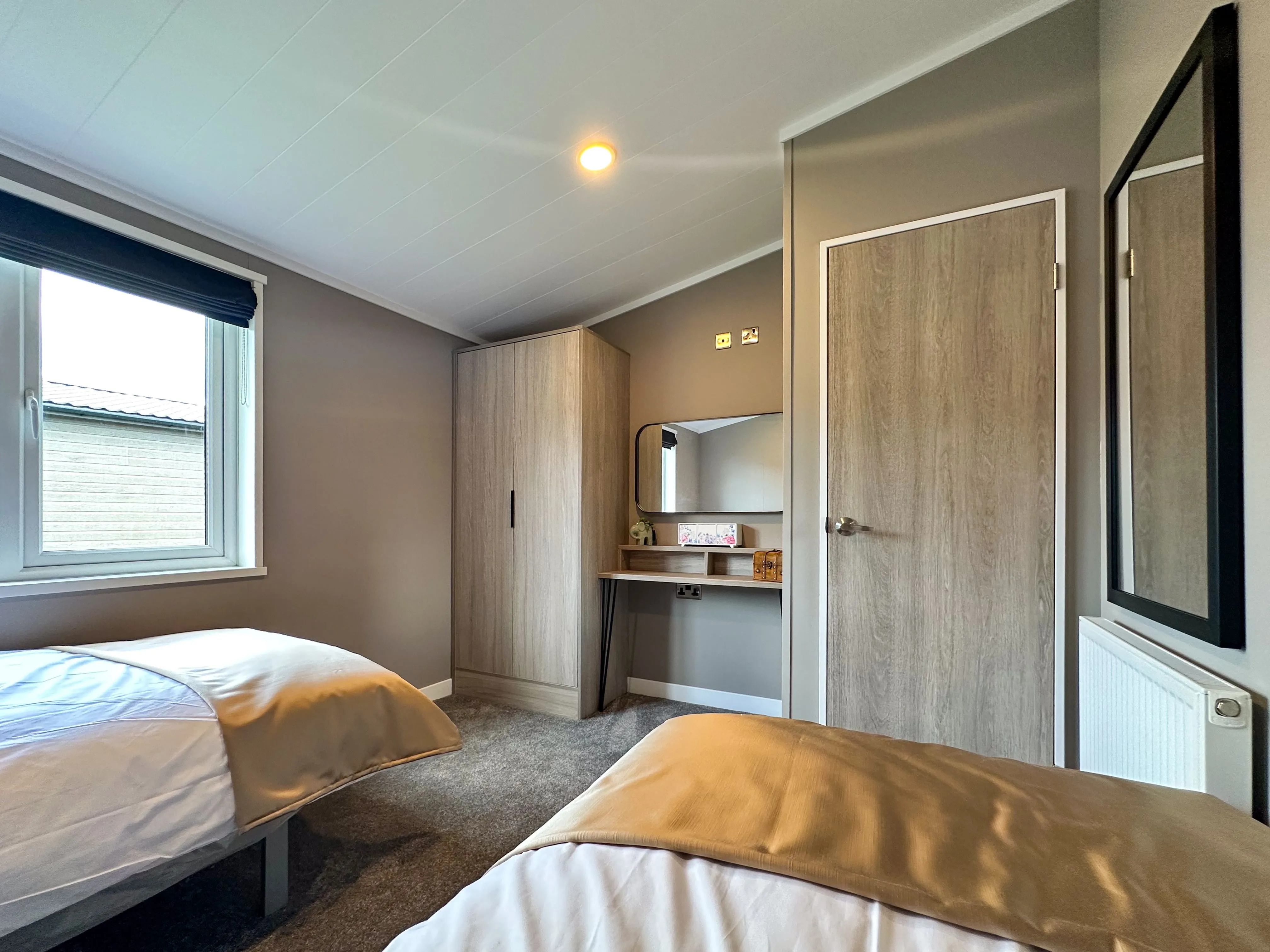 Modern twin bedroom with two single beds, wardrobe and dressing table